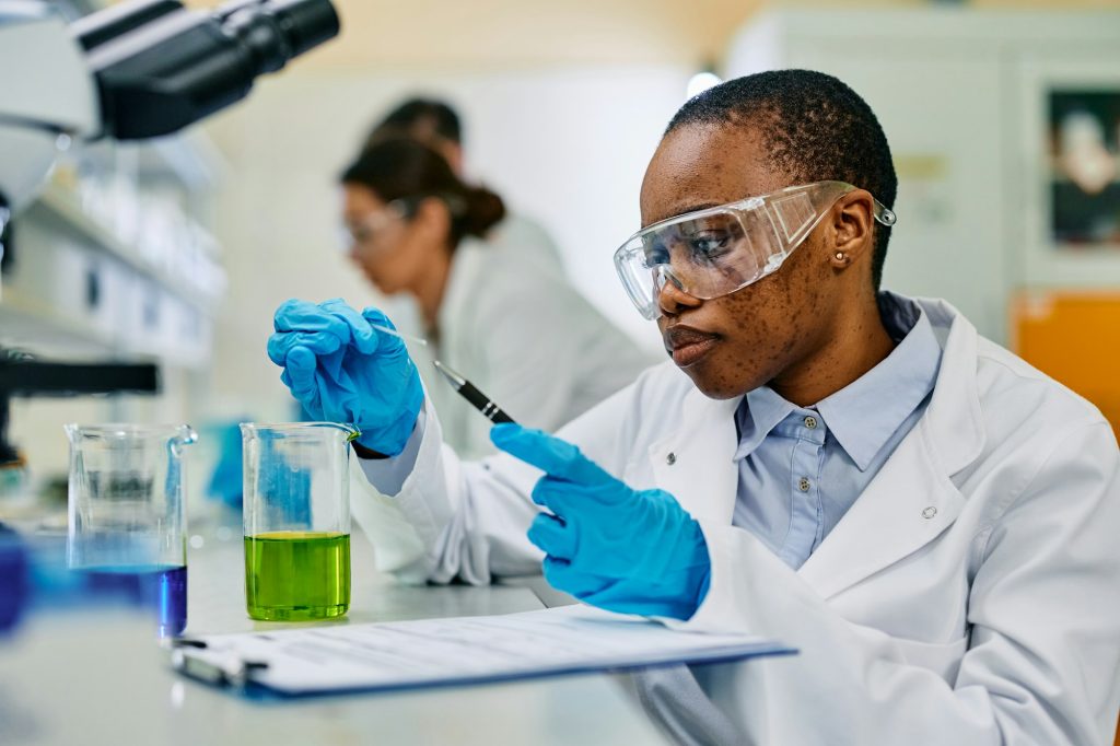 Black female microbiologist doing a research in pharmaceutical laboratory.