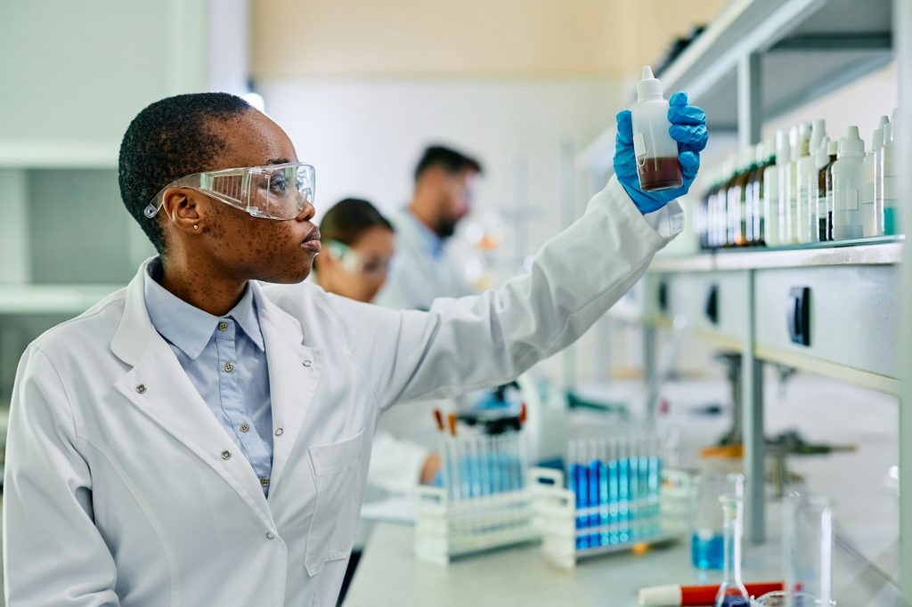 Black female pharmaceutical scientist working in laboratory.